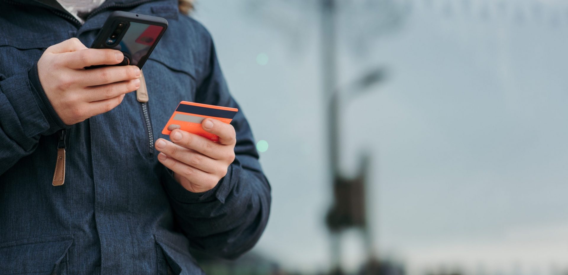 Person holding a credit card and a phone